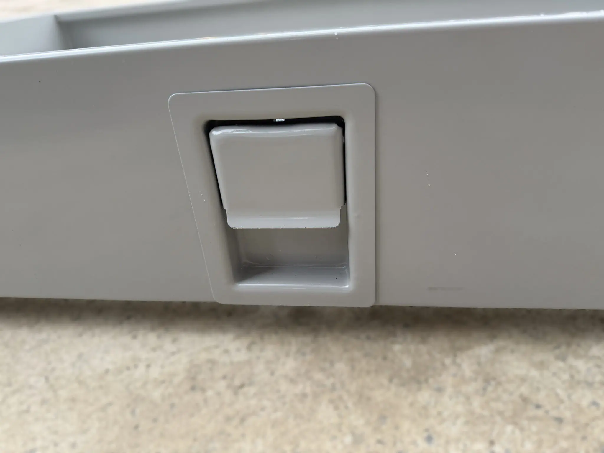 Gray heavy duty pull out storage drawer closeup showing latch handle and slides
