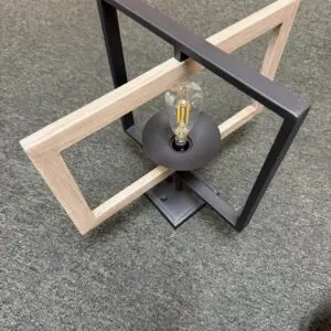 12V RV pendant light with black metal frame crossed by a light wood frame and a filament LED bulb
