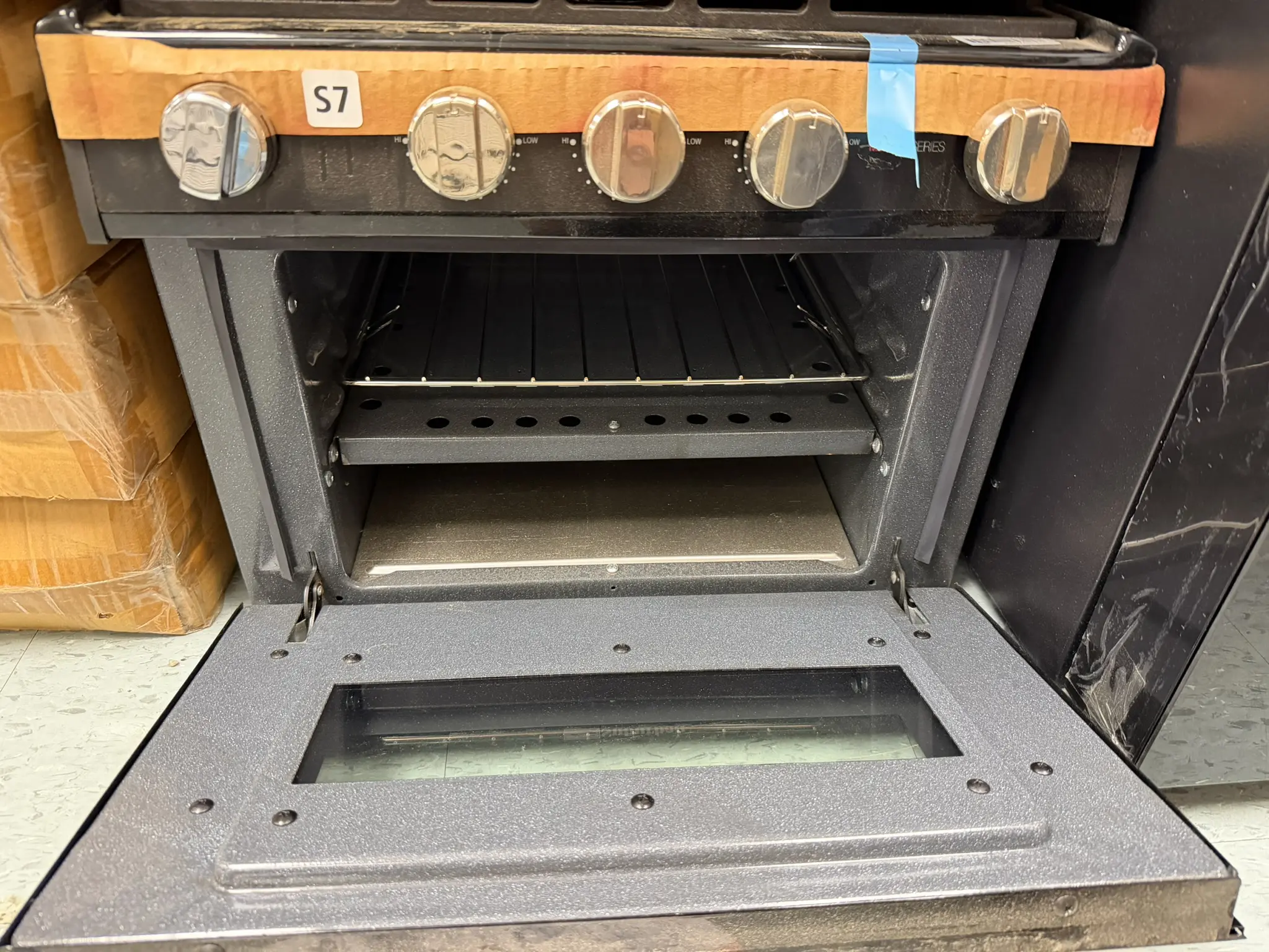 Suburban 17 inch RV range with oven door open showing rack and broiler pan